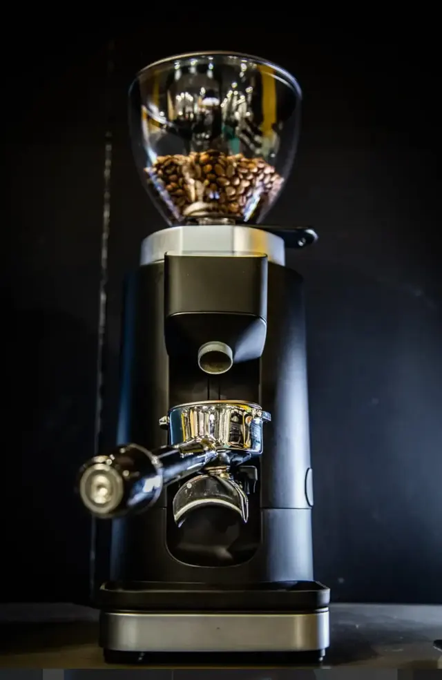 Dalla Corte Edge with the portafilter in its holder, on a dark background
