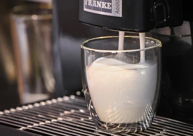Franke A600, milk foam pouring into a glass, close-up