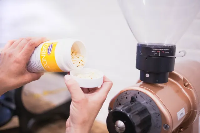 Urnex Grindz tablets next to a coffee grinder